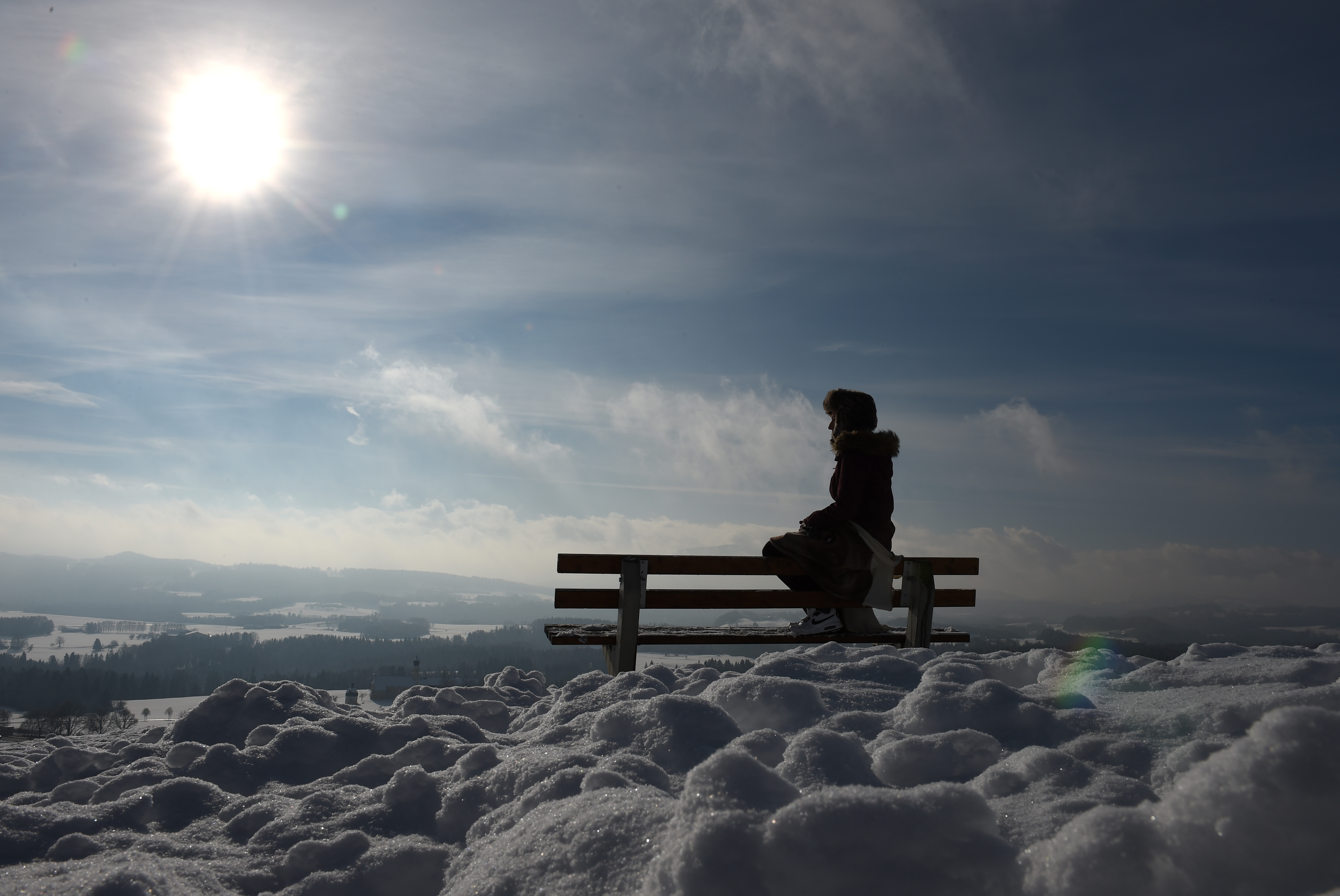 Navidad 2017: Versículos y Oraciones de la Biblia para compartir - A young girl sits on a bench and enjoys the sunny winter weather with temperatures by the freezing point at a snowy landscape near the small Bavarian village Irschenberg, southern Germany, on January 20, 2016. / AFP / Christof STACHE (Photo credit should read CHRISTOF STACHE/AFP/Getty Images)