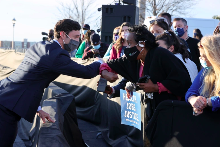 El candidato demócrata al Senado de los Estados Unidos, Jon Ossoff, saluda a sus seguidores.