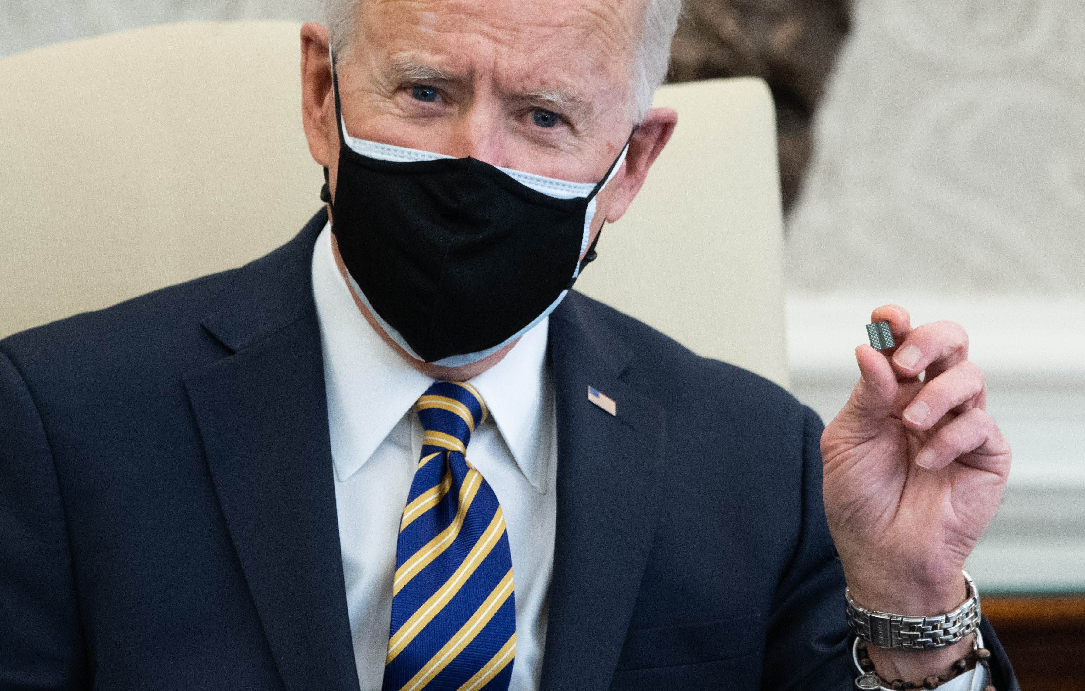 El presidente de los Estados Unidos, Joe Biden, sostiene un microchip mientras habla durante una reunión con miembros de la Cámara y el Senado sobre interrupciones en la cadena de suministro debido al coronavirus en la Oficina Oval de la Casa Blanca