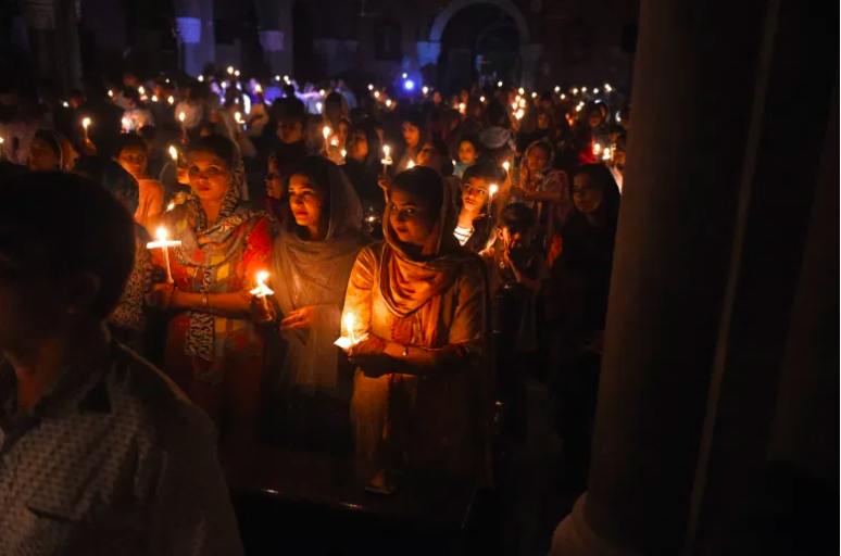 Devotos cristianos paquistan&iacute;es sosteniendo velas mientras asisten a una misa de vigilia de Pascua en la Iglesia del Sagrado Coraz&oacute;n en Lahore el 31 de marzo de 2018.