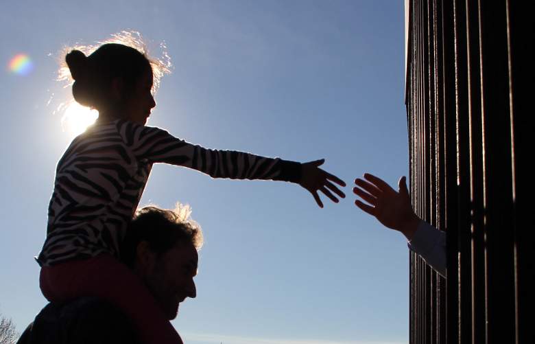 Una niña de Anapra, un barrio en las afueras de Ciudad Juárez en México, le da la mano a una persona en los Estados Unidos a través del cerco fronterizo, durante una oración con sacerdotes y obispos de ambos países para preguntar por los migrantes y la gente de la zona. , el 26 de febrero de 2019.