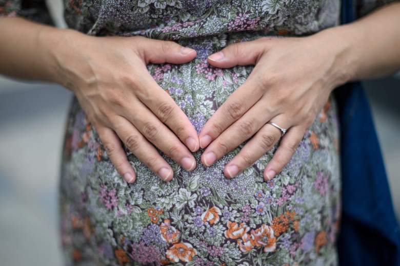 En esta foto tomada el 31 de marzo de 2020, la futura madre Jamie Chui, de 33 años, apoya sus manos sobre la panza de su bebé mientras habla con AFP en Hong Kong