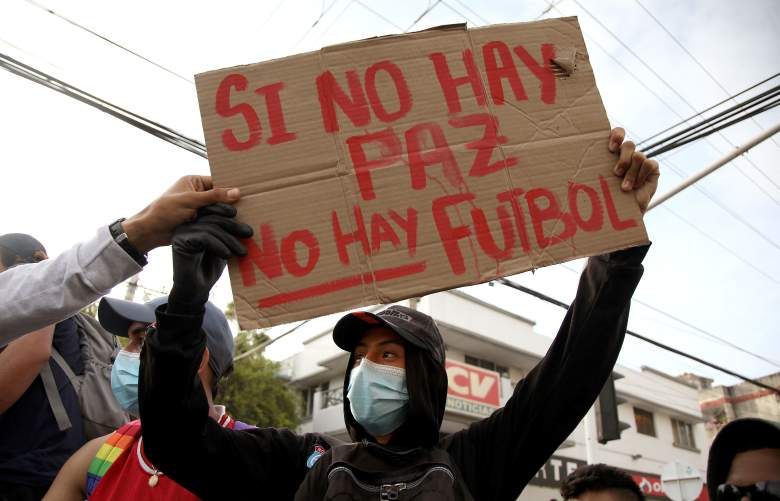 Un manifestante sostiene una pancarta que dice 'No hay paz, no hay fútbol' afuera del estadio Romelio Martínez en Barranquilla, Colombia, antes del inicio del partido de la Copa Libertadores entre América de Cali y Atlético Mineiro el 13 de mayo de 2021.