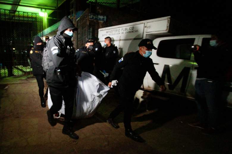 Agentes de la policía transportan el cadáver de un recluso después de una pelea en la prisión de hombres de Cantel, en el departamento de Quetzaltenango, 205 km al oeste de la ciudad de Guatemala, el 19 de mayo de 2021.