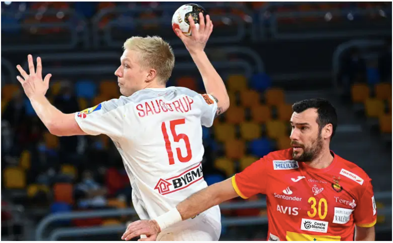 El pivote de Dinamarca Magnus Saugstrup (L) intenta un tiro cuando es desafiado por el pivote de España Gedeon Guardiola (R) durante el partido de semifinales del Campeonato Mundial de Balonmano Masculino 2021 entre España y Dinamarca en el Estadio de El Cairo en la capital egipcia el 29 de enero de 2021 (Foto de Anne-Christine POUJOULAT / AFP) (Foto de ANNE-CHRISTINE POUJOULAT / AFP a través de Getty Images)