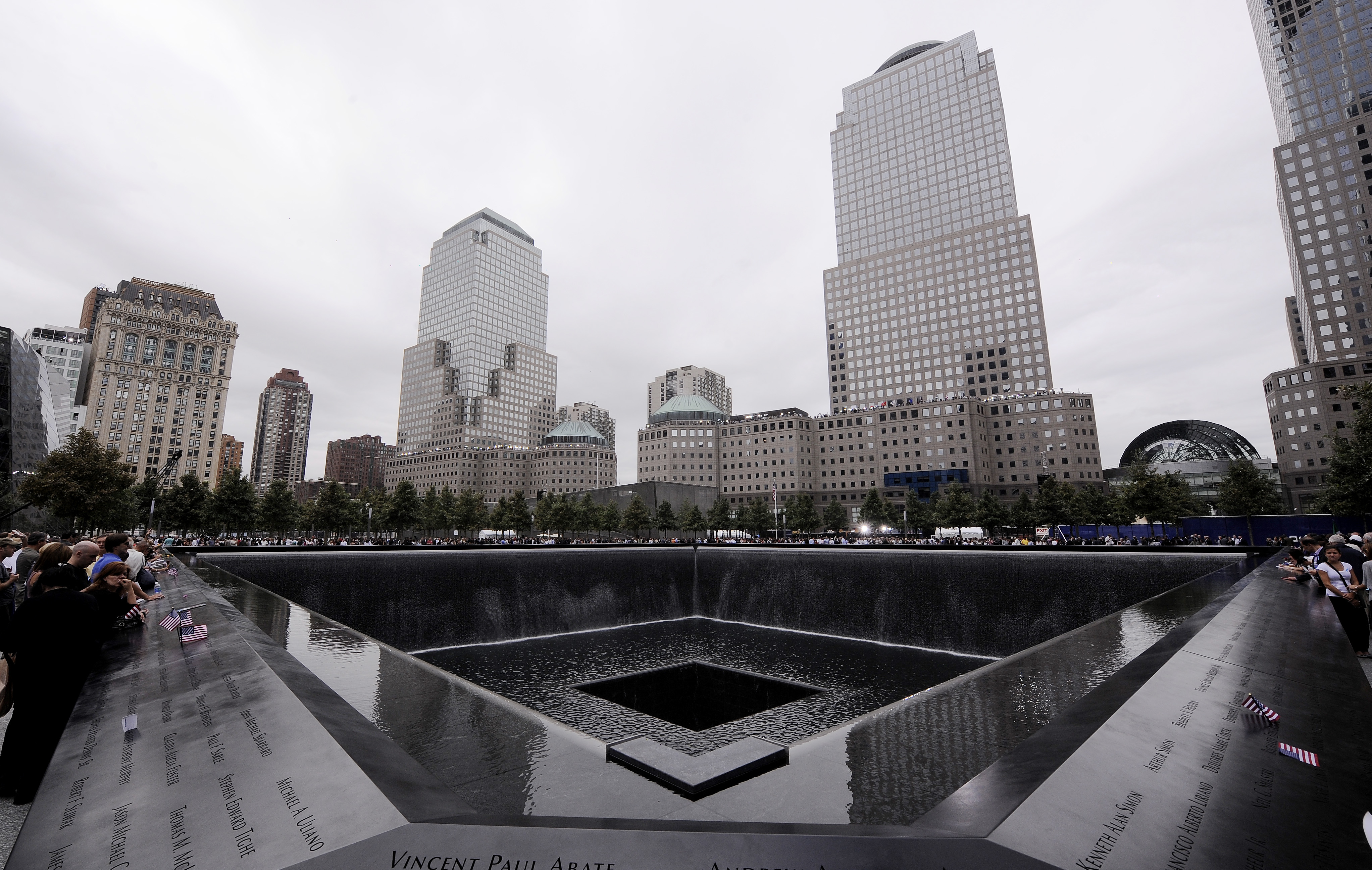 Los miembros de la familia se reúnen en el borde de la piscina norte del 9/11 Memorial durante las ceremonias del décimo aniversario de los ataques terroristas del 11 de septiembre de 2001 en el sitio del World Trade Center, 11 de septiembre de 2011 en Nueva Ciudad de York.