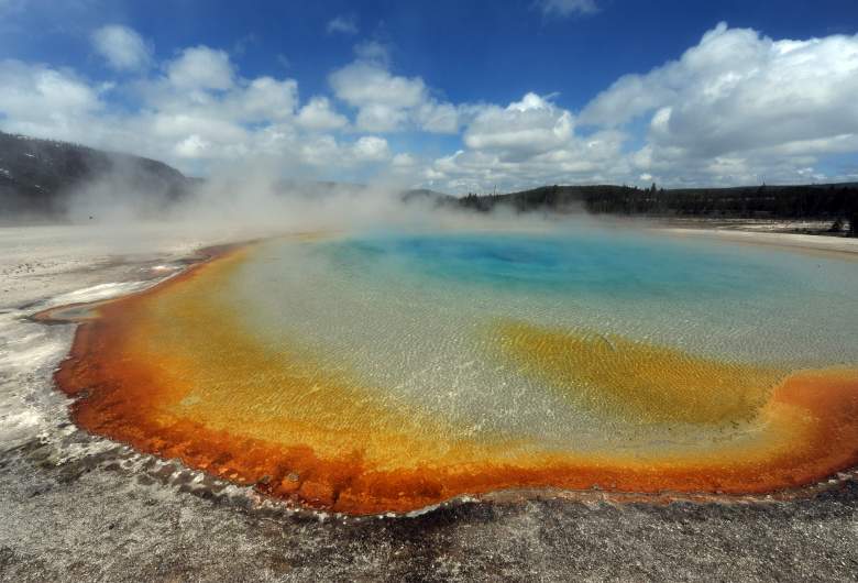 Vista de la fuente termal 'Sunset Lake' con sus colores únicos causados por bacterias parecidas a las algas marrones, naranjas y amarillas llamadas Thermophiles, que prosperan en el agua de enfriamiento convirtiendo los vívidos azules acuáticos en un marrón verdoso más oscuro, en el Parque Nacional de Yellowstone.