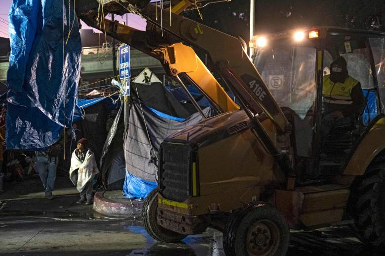 Los migrantes son vistos mientras las autoridades desmantelan un campamento improvisado afuera del puerto de cruce de El Chaparral en Tijuana, estado de Baja California, México, cerca de la frontera con los EE. UU., el 6 de enero de 2022.